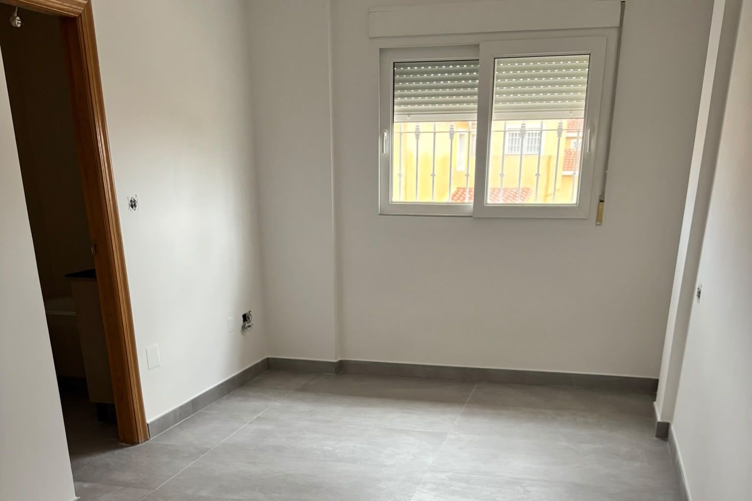 Dormitorio con suelo porcelánico gris de gran formato